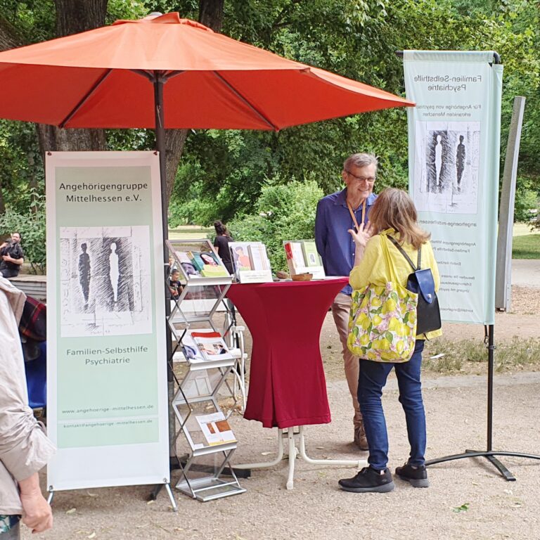 Infostand auf der Selbsthilfemeile des Wetteraukreises, am 1. Juli 2023 in Bad Nauheim. Peter Valenta im Gespräch mit einer interessierten Frau.